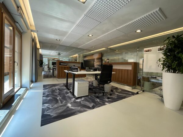 Moderne kantoorruimte aan de Charloisse Lagedijk met glazen wanden, houten accenten en een bureau met computerschermen.